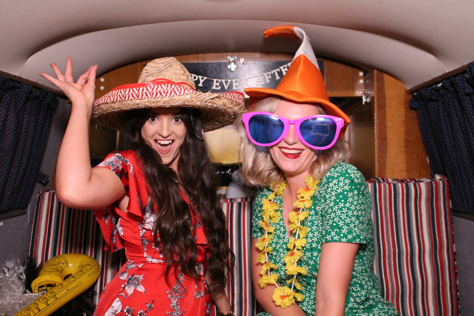 bride and bridesmaid having funny photos in the vw camper photo booth van